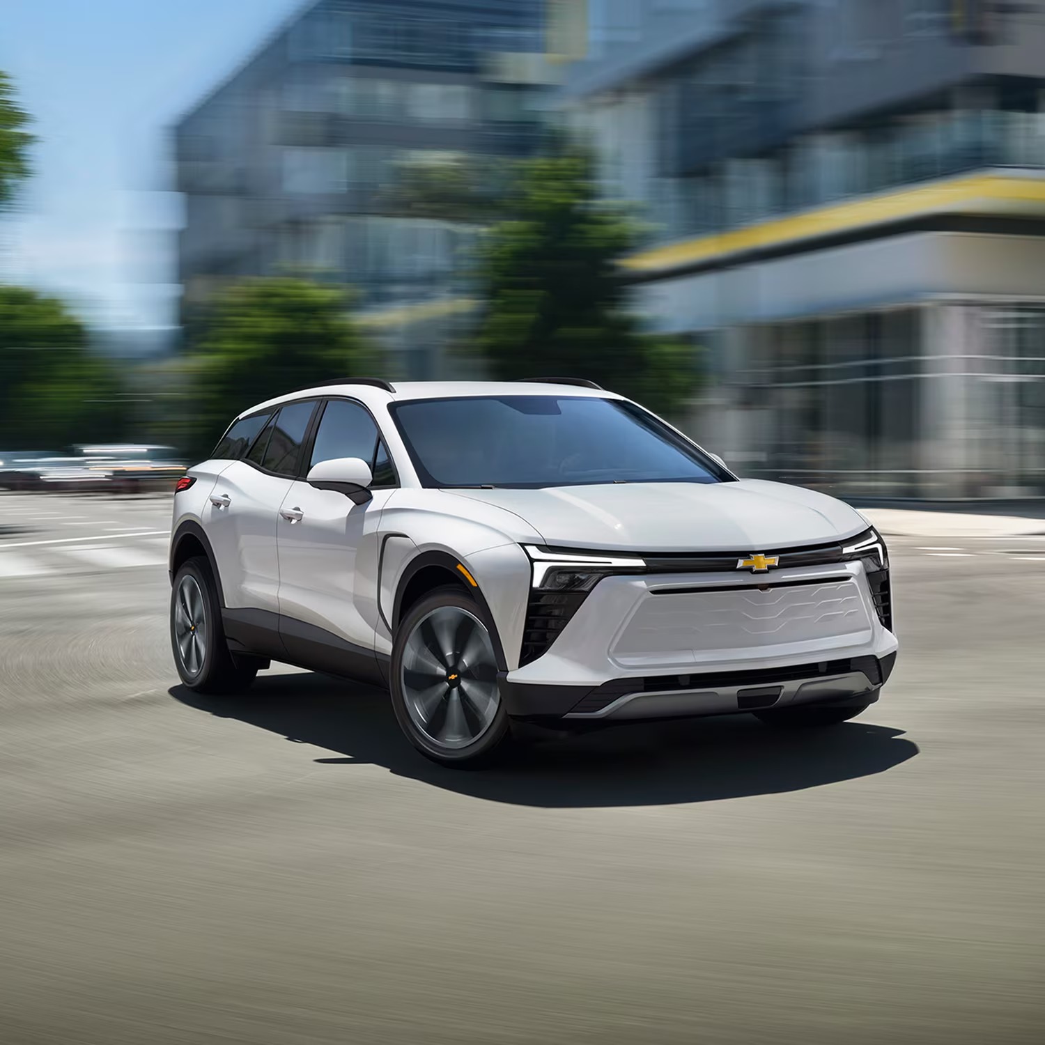 White Chevy Blazer EV driving through a city intersection