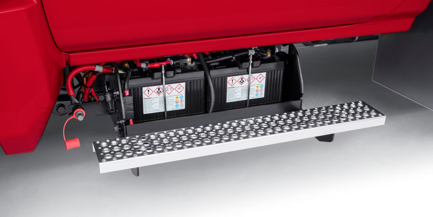 Dual batteries mounted under the cab step of a red Chevy Silverado 4500HD chassis cab