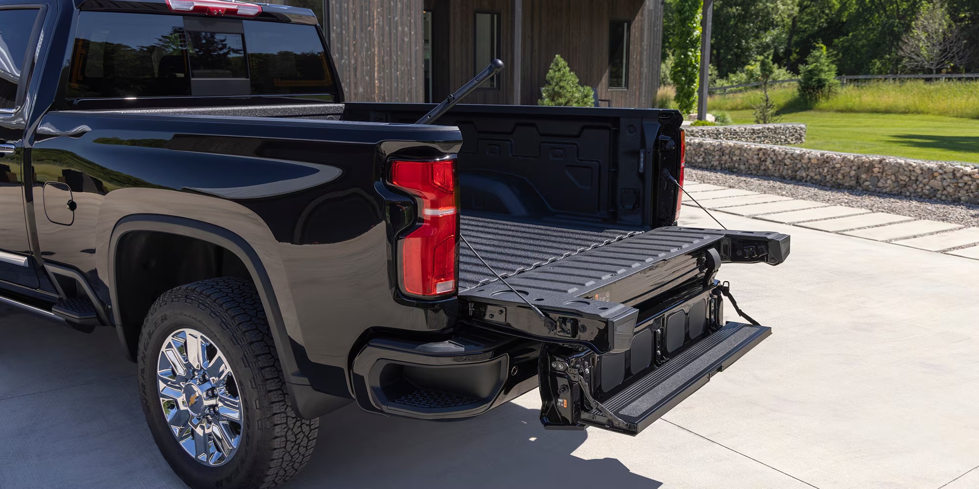 Black Chevy Silverado HD High Country with the multi-function tailgate open in a driveway