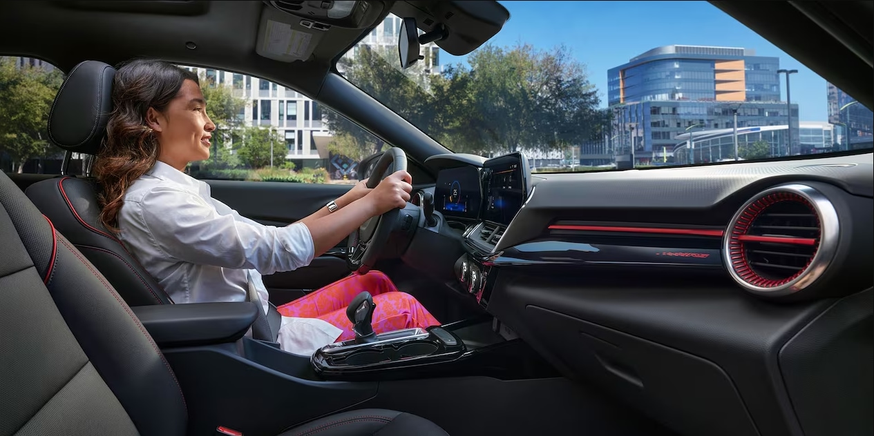A view of a woman driving a 2023 Chevy Trax and the dash and infotainment system.