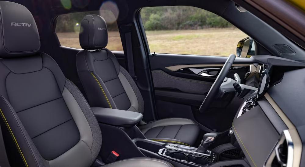 The black and grey interior of a 2024 Chevy Trailblazer Activ is shows the front seating and center console.