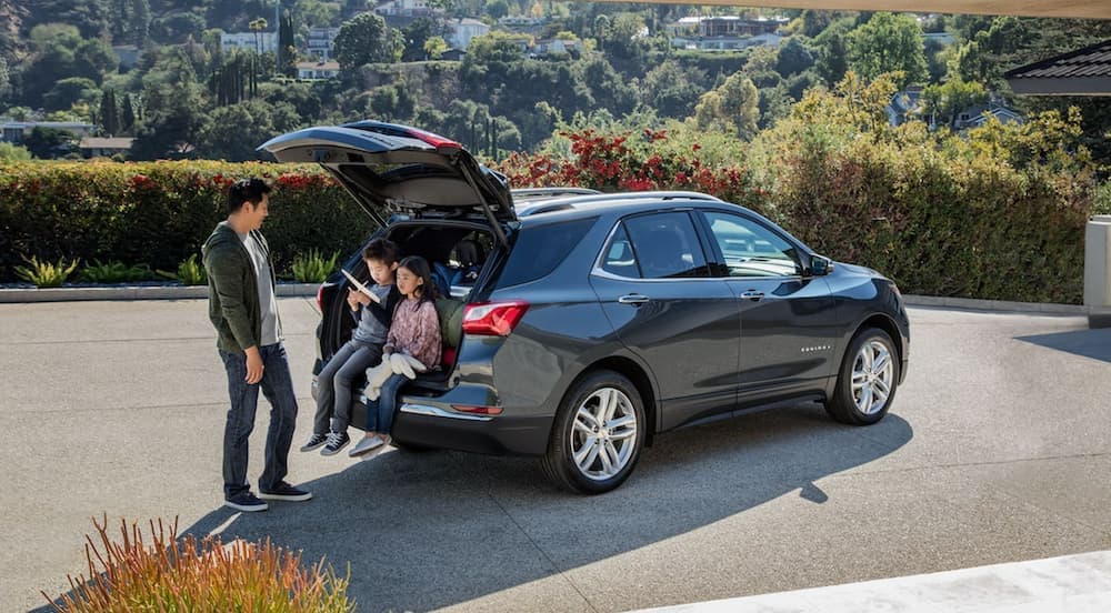 A grey 2021 Chevy Equinox is shown from a rear angle with the rear liftgate open.