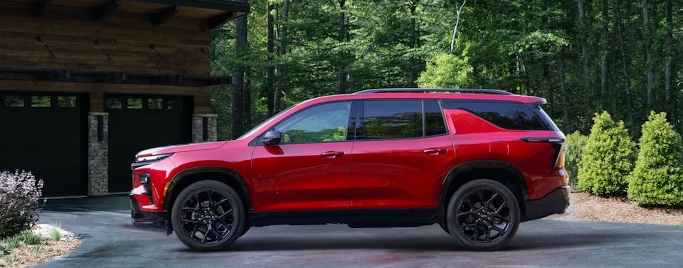 A red 2024 Chevy Traverse is shown from the parked in a driveway.