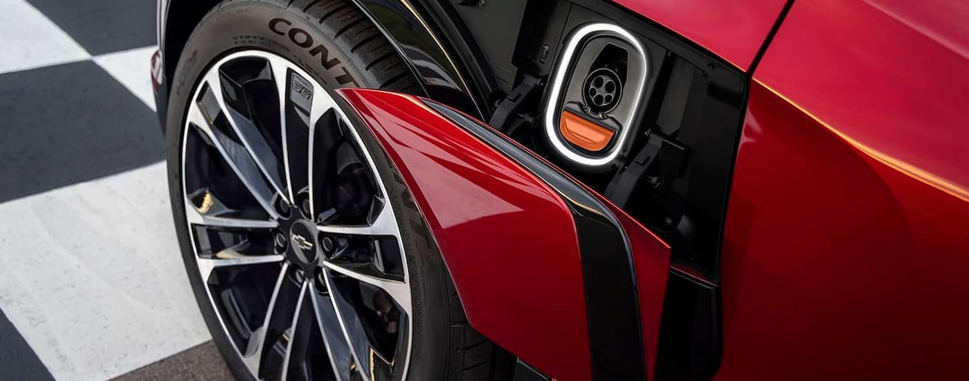 A close up of the charging plug on a red 2024 Chevy Blazer EV is shown.