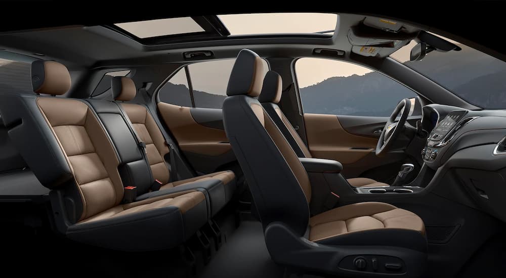 The brown and black interior of a 2022 Chevy Equinox RS shows the two rows of seating.