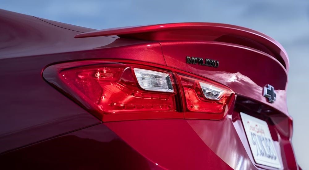 A close up shows the spolier on a red 2023 Chevy Malibu.