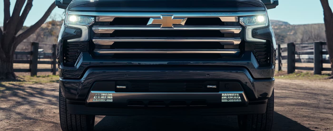 A close up of the grille on a blue 2024 Chevy Silverado 1500 High Country is shown.