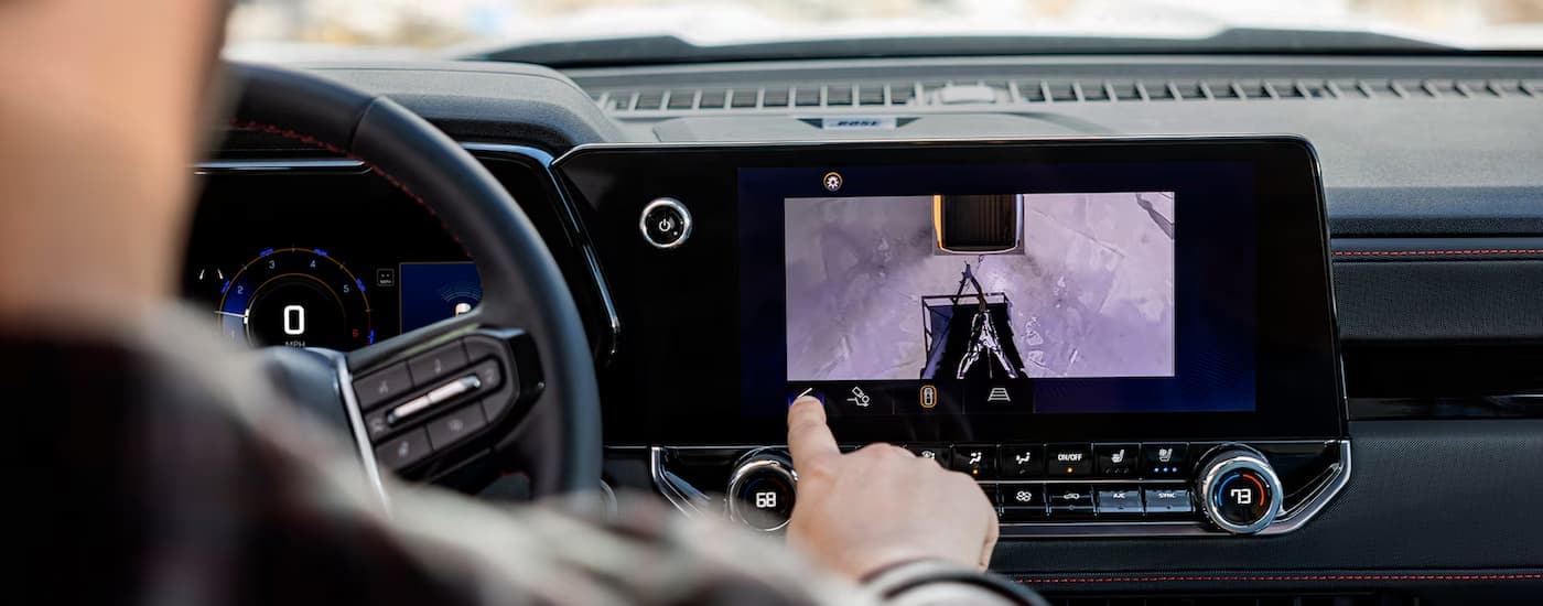 A person is using the infotainment screen in a 2024 Chevy Colorado.