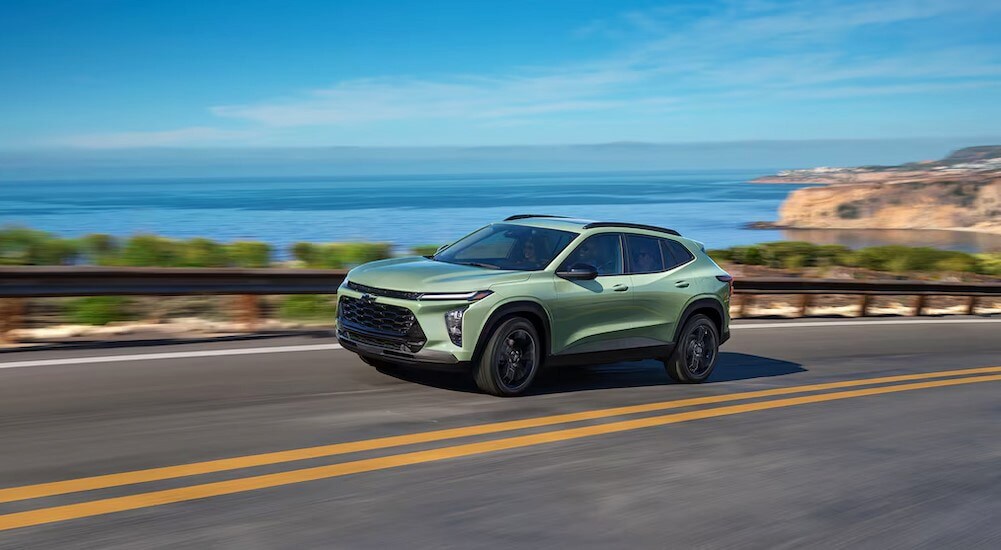 A green 2025 Chevy Trax ACTIV is shown driving on a highway after viewing a Chevy Trax for sale near Lancaster.