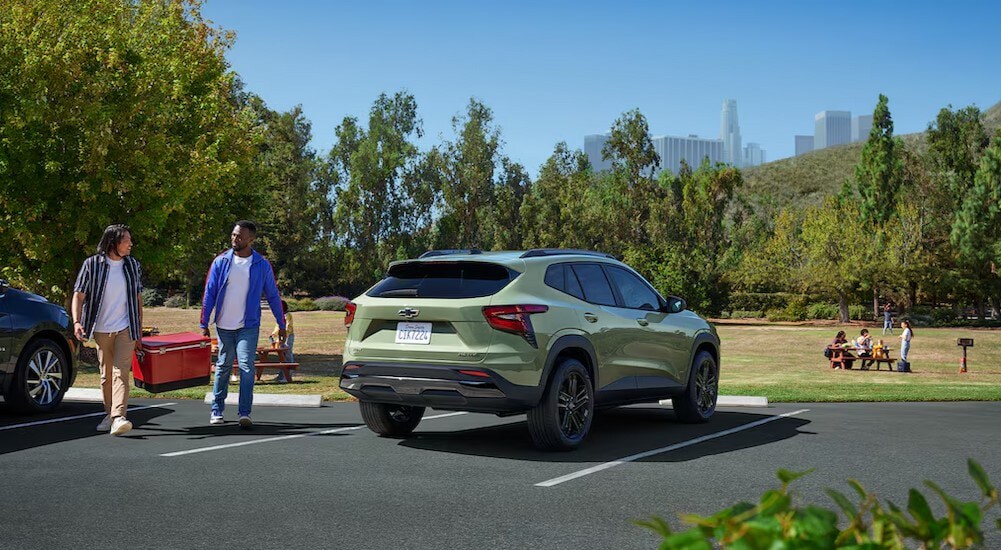 A green 2025 Chevy Trax ACTIV is shown parked near people at a park.