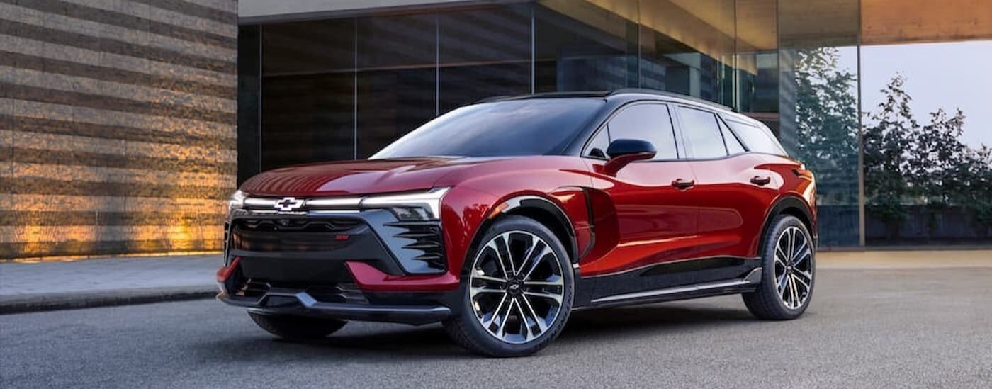 A red 2024 Chevy Blazer EV RS is shown parked near a modern building.