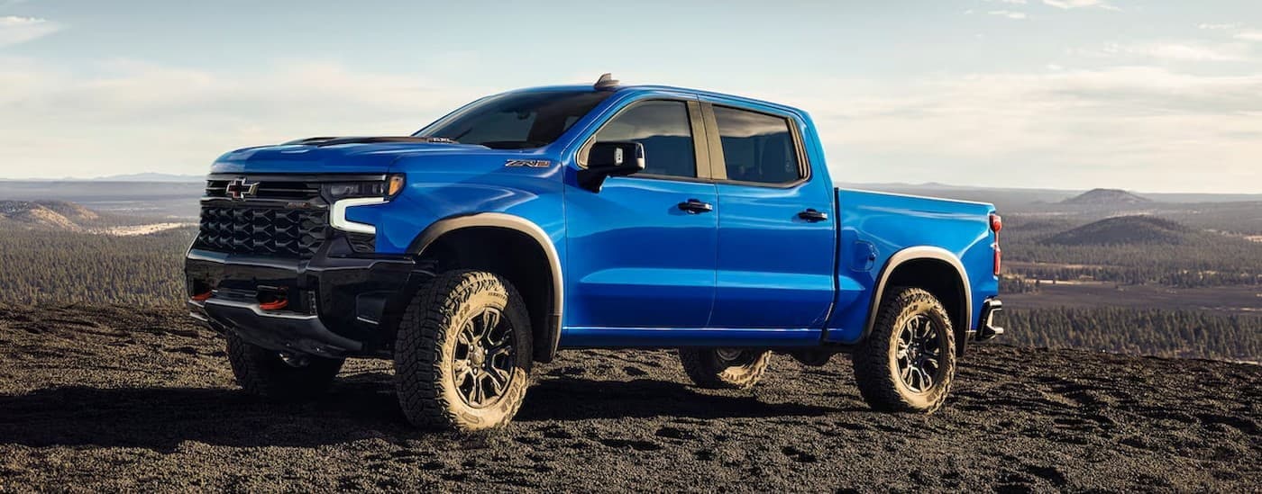 A blue 2025 Chevy Silverado 1500 ZR2 is shown parked off-road.