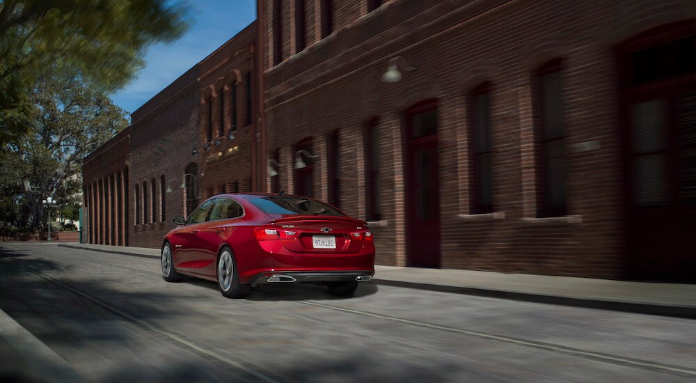 A red 2024 Chevy Malibu RS is shown from the rear at an angle.