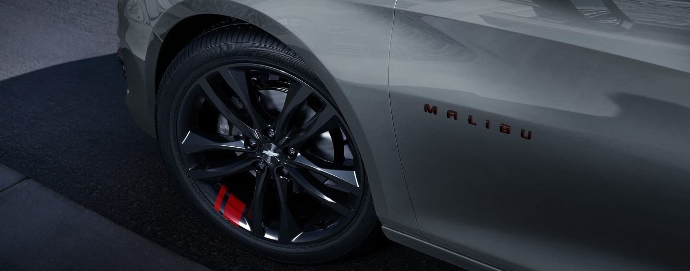 A close-up on the wheel of a silver 2024 Chevy Malibu Redline.