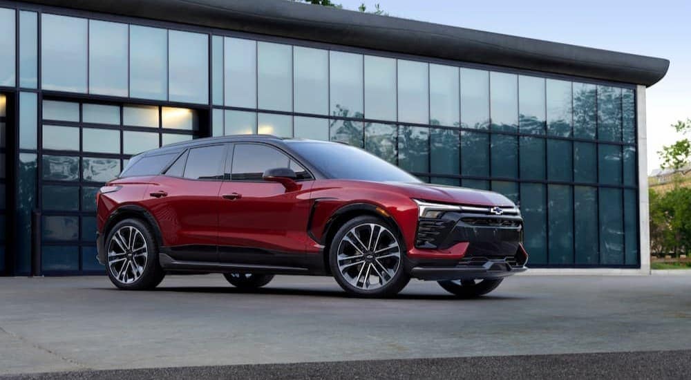 A red 2024 Chevy Blazer RS EV is shown parked near glass garage doors.