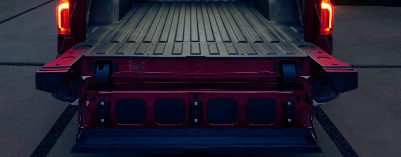 A close-up of the Multi-Flex tailgate is shown on a red 2025 Chevy Silverado 1500.
