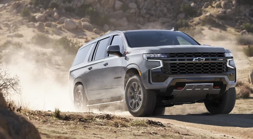 A gray 2024 Chevy Suburban Z71 is shown driving off-road.