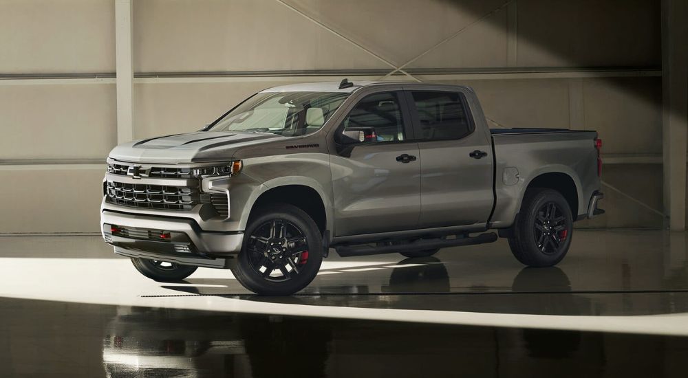 A silver 2024 Chevy Silverado 1500 Redline is shown parked in a warehouse.