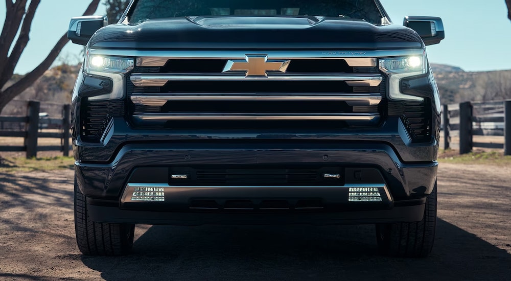 A dark blue 2024 Chevy Silverado 1500 High Country, a popular Chevy Silverado 1500 for sale, is shown from the front.