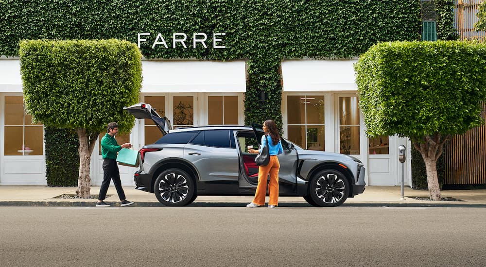 A silver 2024 Chevy Blazer EV RS is parked outside of a store.