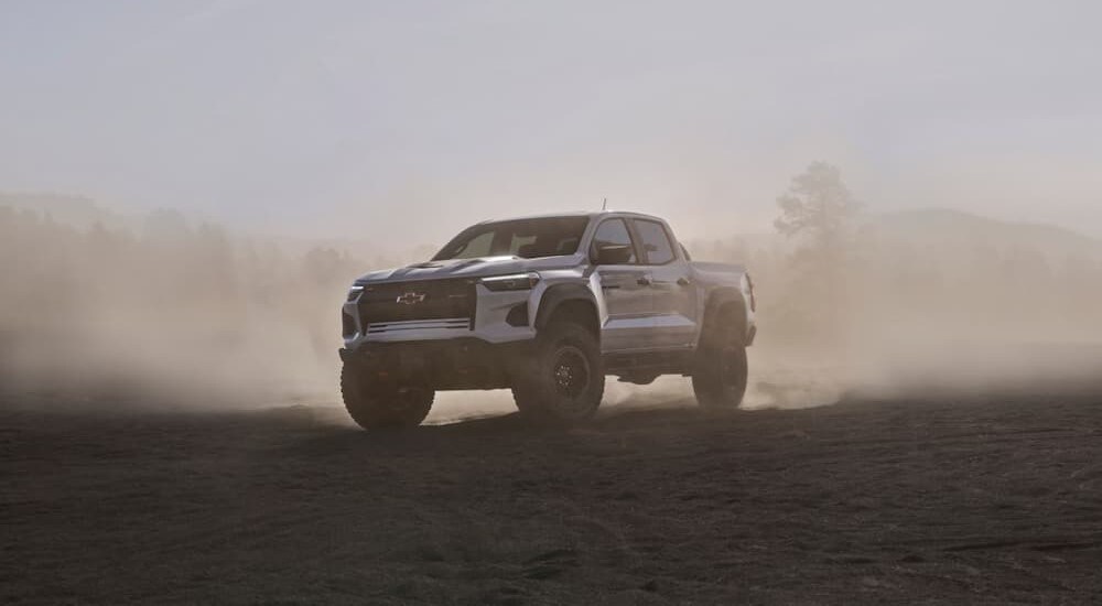 A white 2024 Chevy Colorado ZR2 Bison is shown driving off-road.