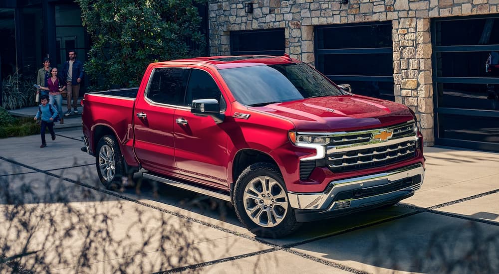 A red 2024 Chevy Silverado 1500 for sale is shown parked in a driveway.