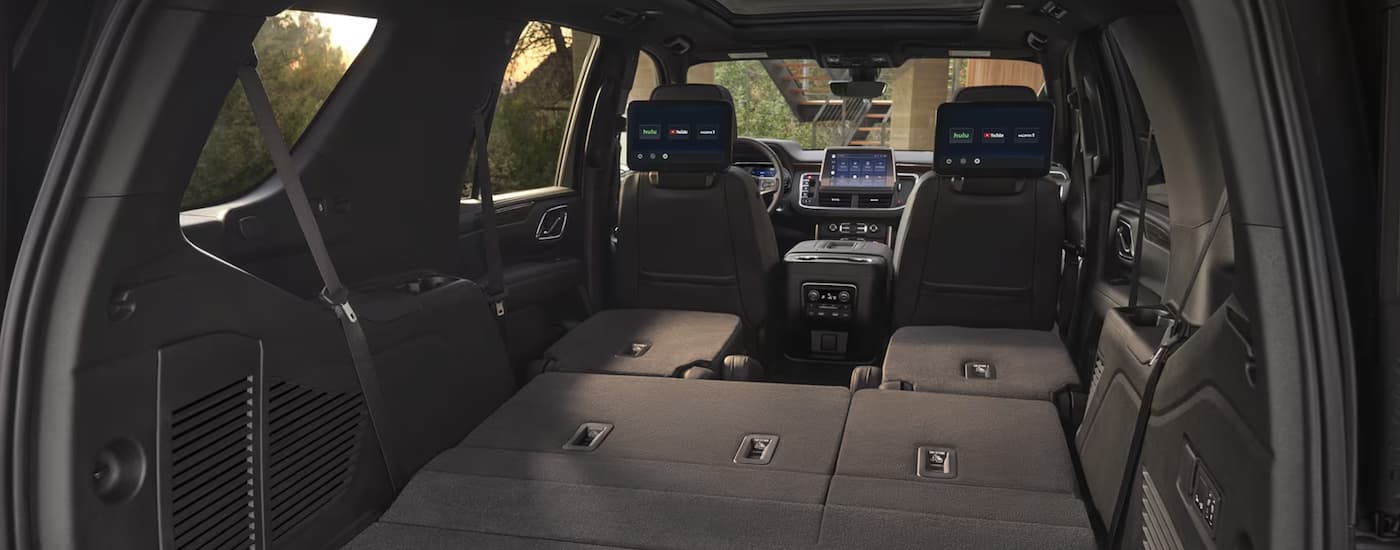 The rear cargo area of a 2024 Chevy Tahoe is shown with the seats folded down.