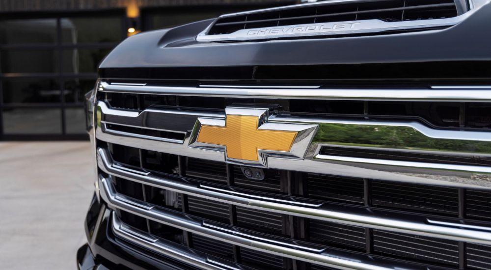 A close up shows the grille on a black 2024 Chevy Silverado 2500 for sale.