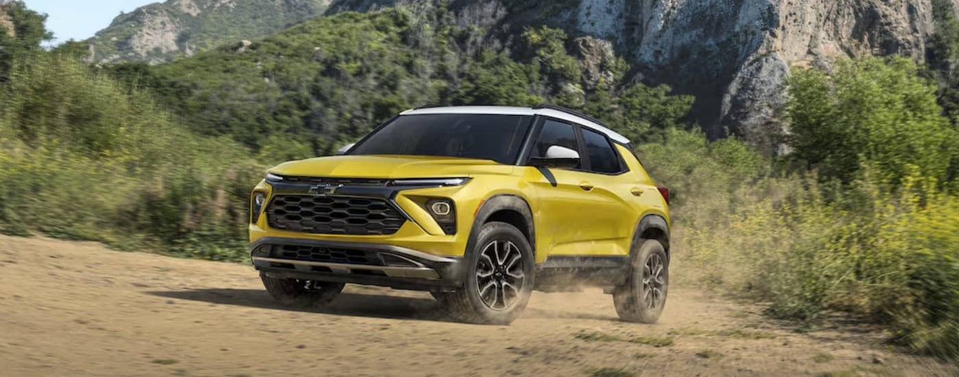 A yellow 2024 Chevy Trailblazer ACTIV is shown driving off-road.