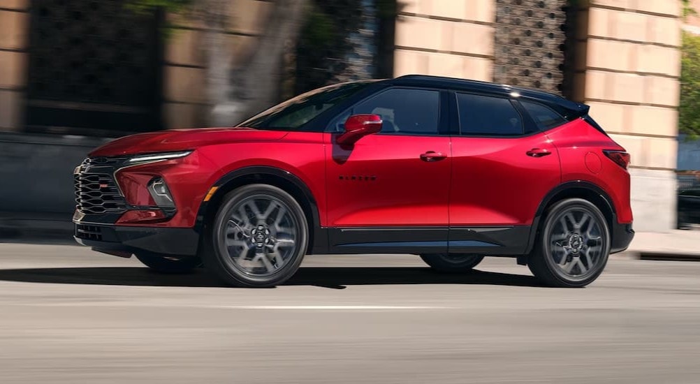 A red 2025 Chevy Blazer RS is shown from the side on a city street.