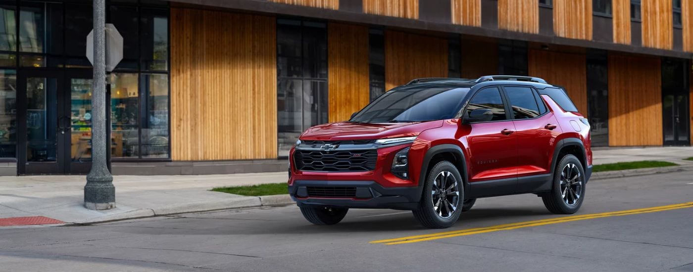 A red 2025 Chevy Equinox RS is shown at an intersection.