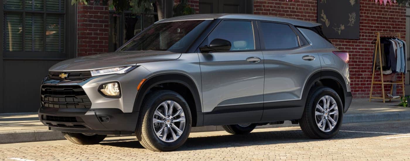 A grey 2023 Chevy Trailblazer is shown from the side parked on a city street after leaving a used Chevy dealer near Powell.