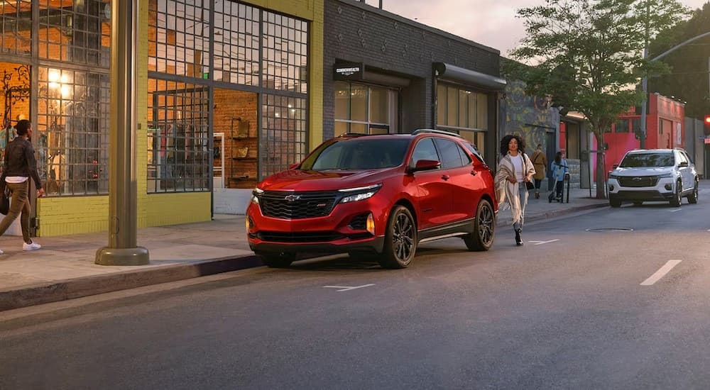  A red 2024 Chevy Equinox RS is shown parked near a store.