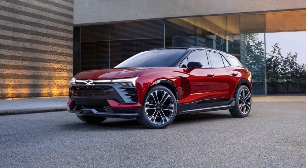 A red 2024 Chevy Blazer EV is shown parked near a a glass building.