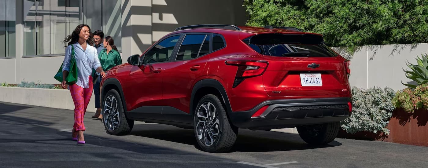 A red 2024 Chevy Trax RS is shown from the rear parked on the side of a street.
