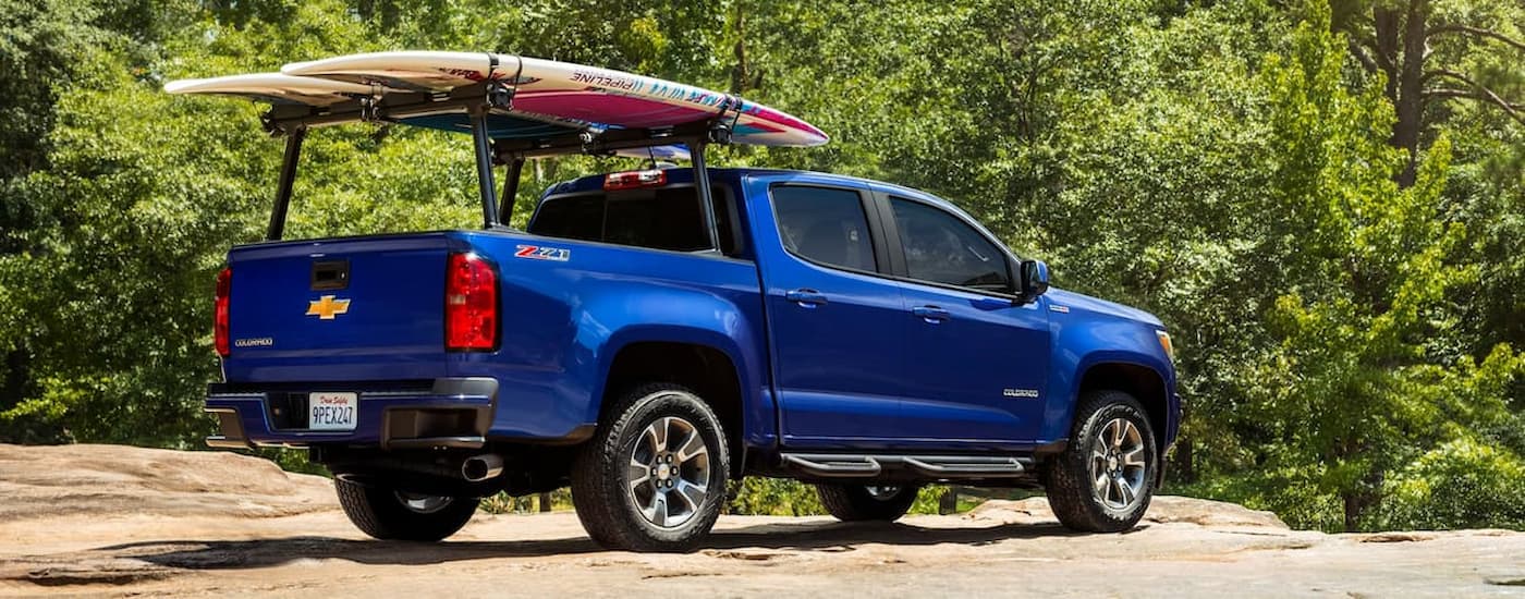 A blue 2019 Chevy Colorado is shown from the rear with kayaks on the back rack.