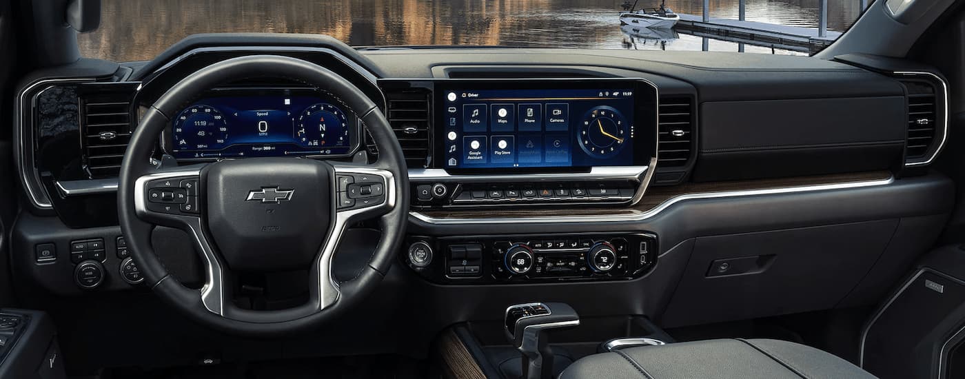 The black interior of a 2023 Chevy Silverado 1500 shows the steering wheel and center console.