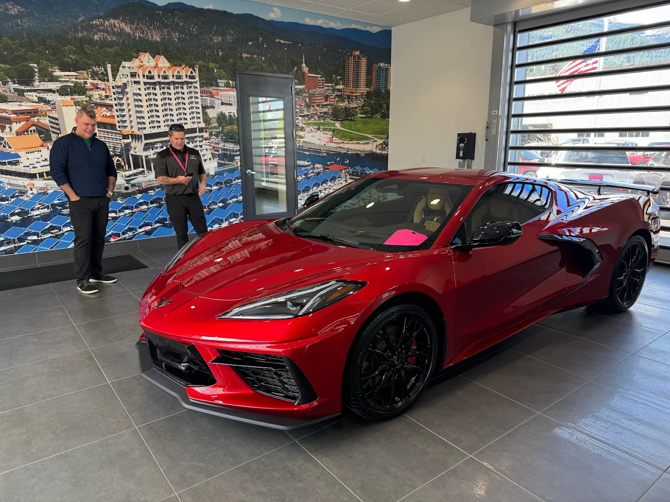 Man standing in front of newly bought corvette inside of Dave Smith Motors