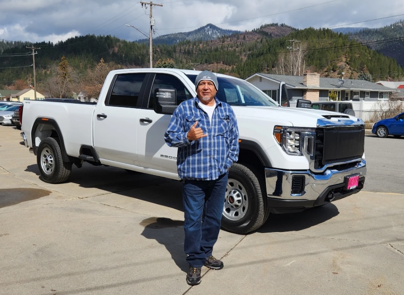 Man standing in front of newly bought pickup truck outside of Dave Smith Motors
