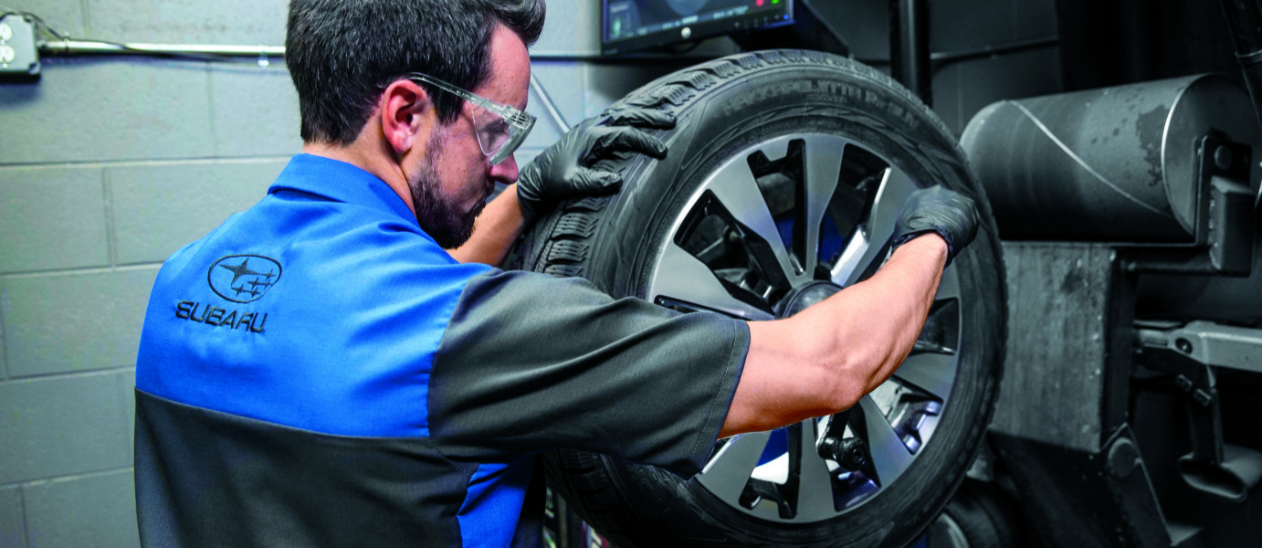 Subaru service staff checking up a tire