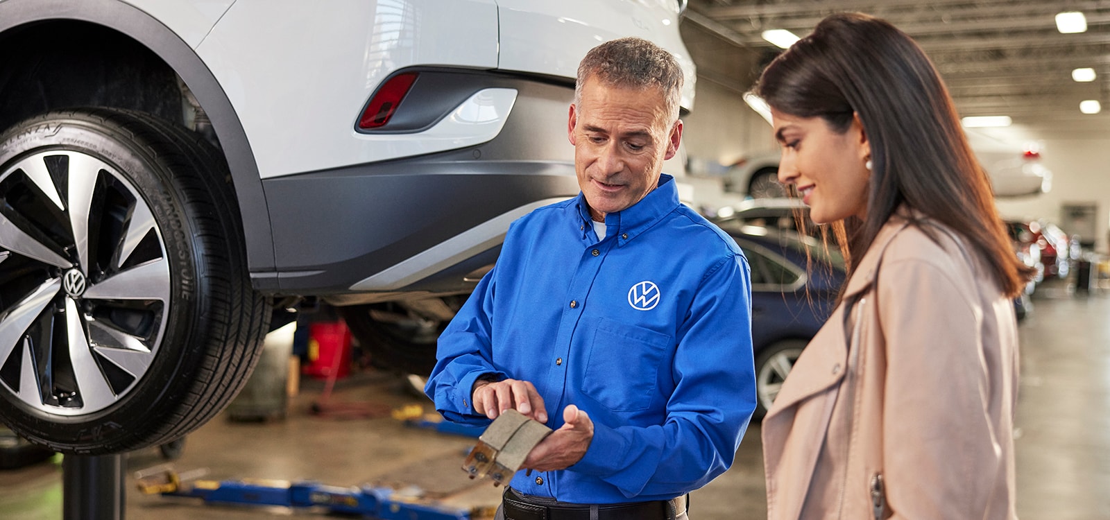  VW mechanic discussing repairs with customer