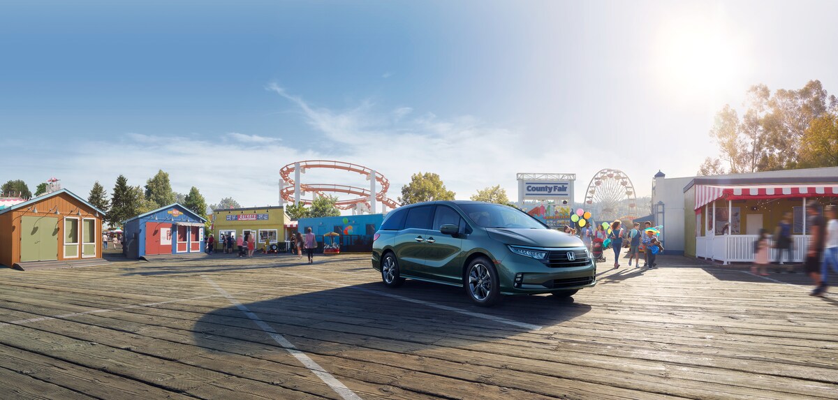 blue Honda Odyssey parked in front of a fair