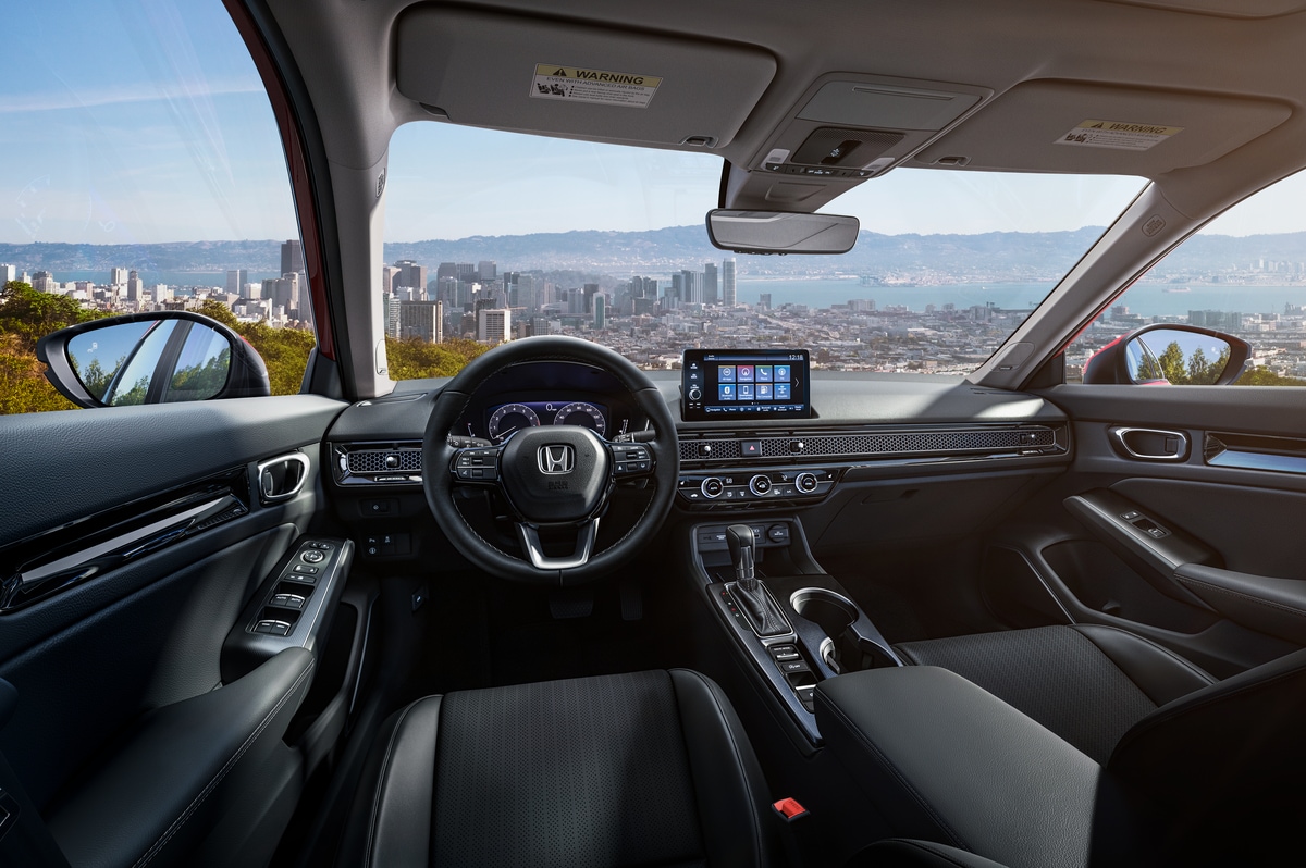 black and gray Honda Civic sedan interior dashboard and steering area, overlooking a city horizon