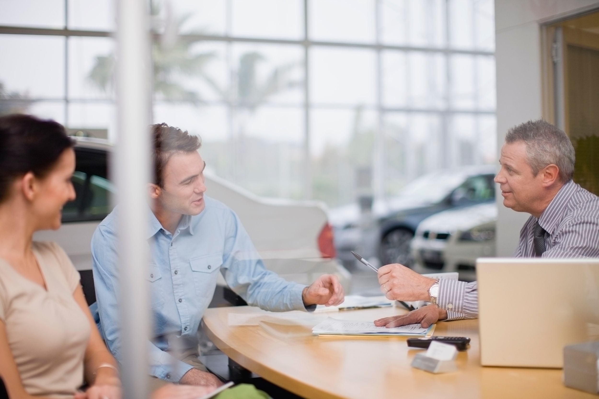 couple signing a lease deal at a car dealership