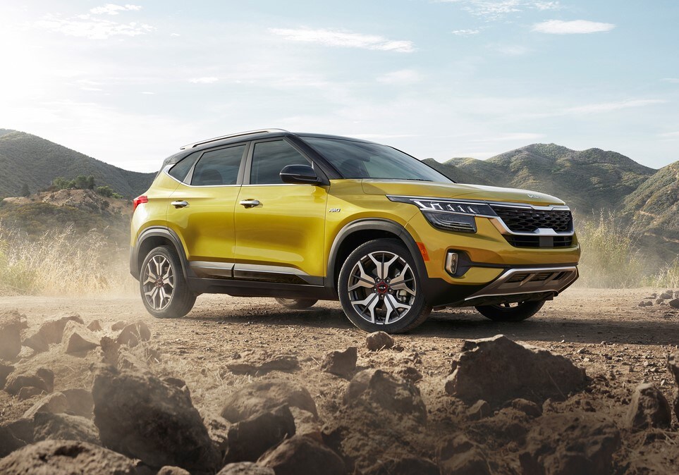 yellow Kia Seltos SUV parked on a dusty, rocky road