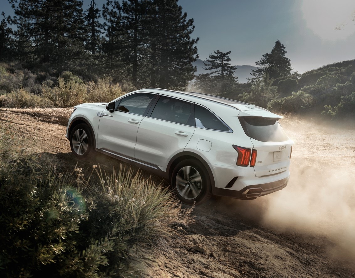 white Kia Sorento SUV driving up a steep, dusty trail hill