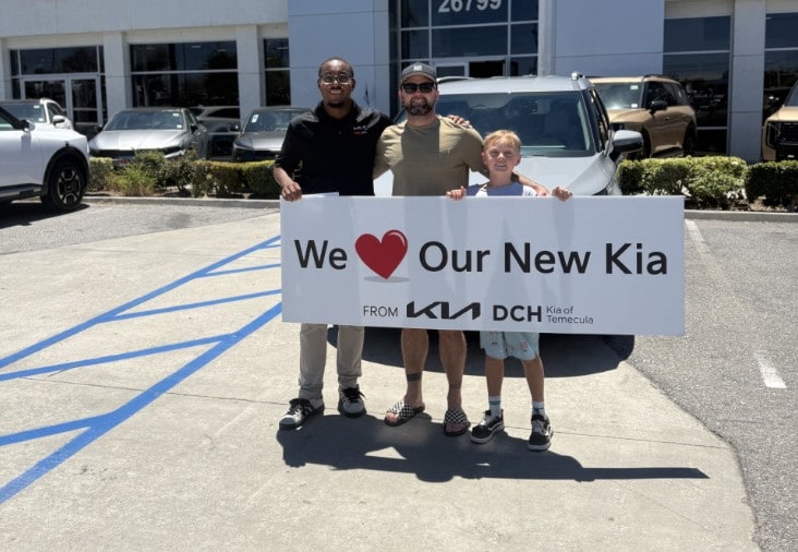 Happy customer and child receiving their new Kia at DCH Kia of Temecula
