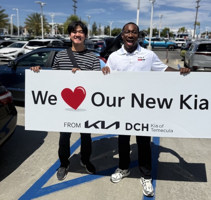 Excited customer celebrating with a DCH Kia of Temecula team member