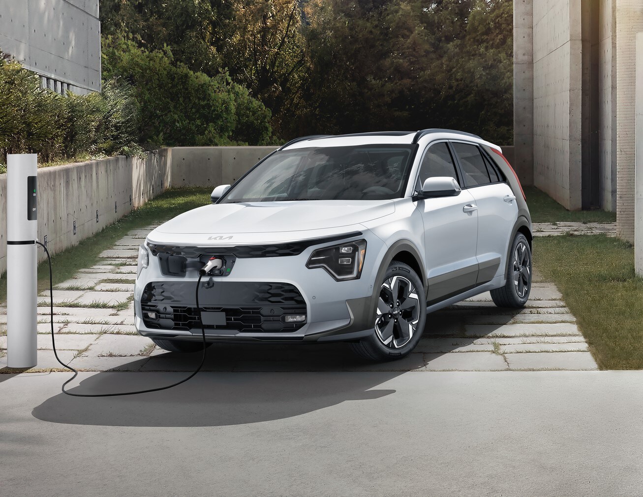 white Kia Niro EV SUV parked and charging with a front charge port