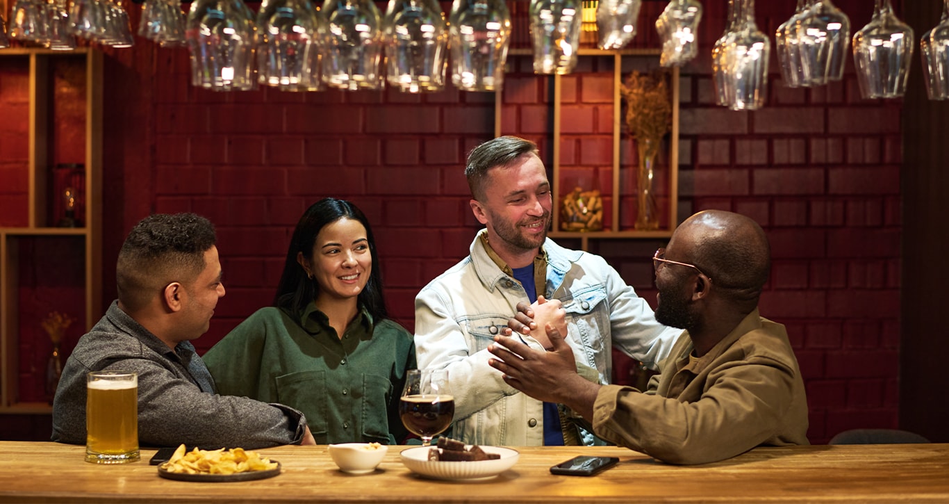 Chevy Dealer in Greensburg | Friends smiling and hanging out inside of a bar 